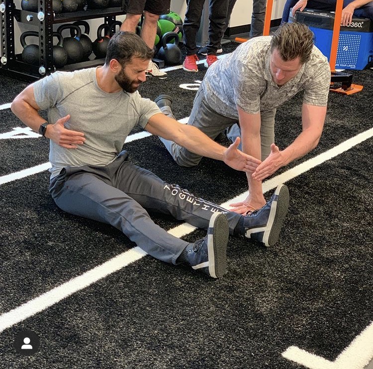 Sean Light coaching a mobility session on the turf